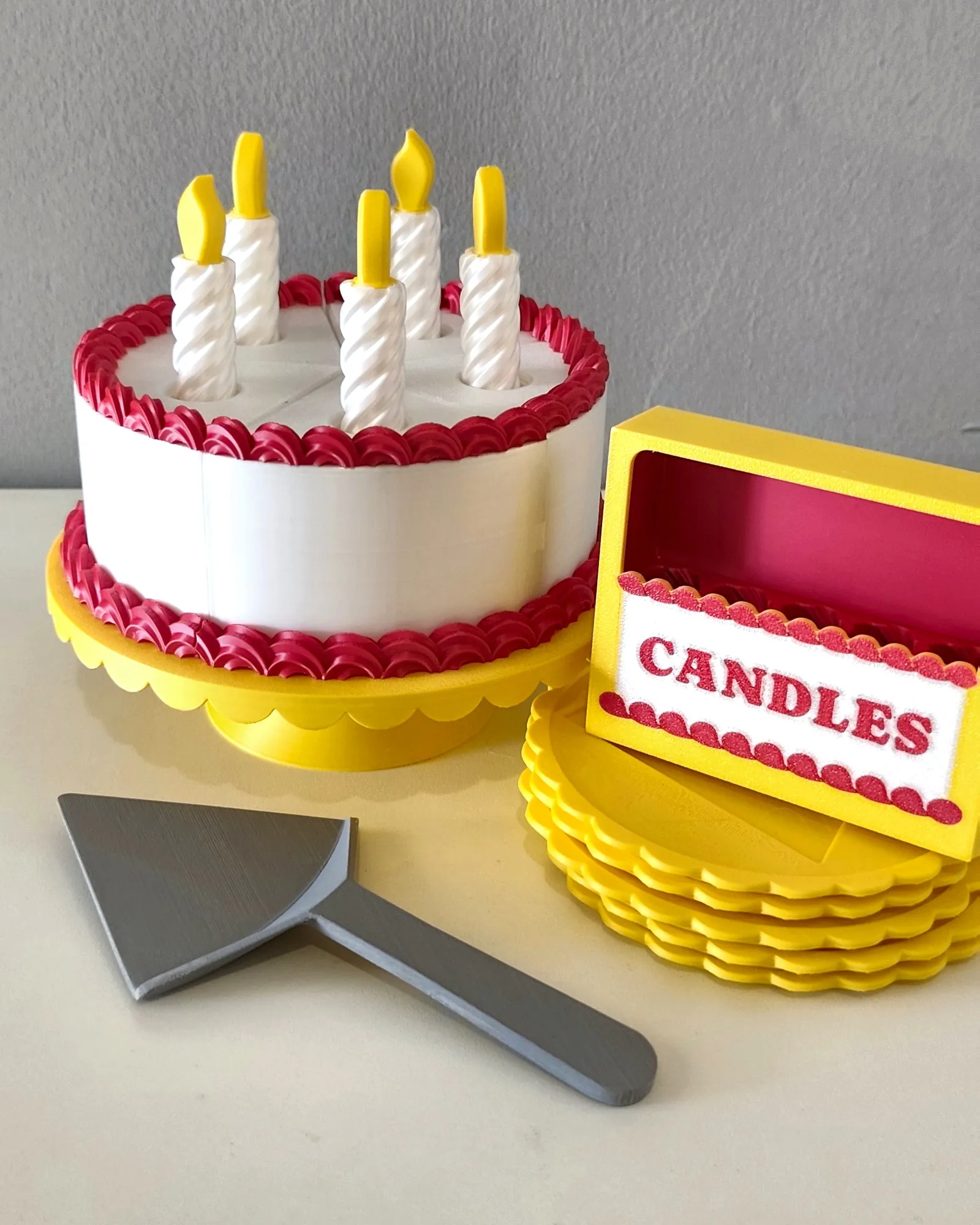 Bolo de aniversário com velas e pá de servir, impresso em 3D pela Dédalo
