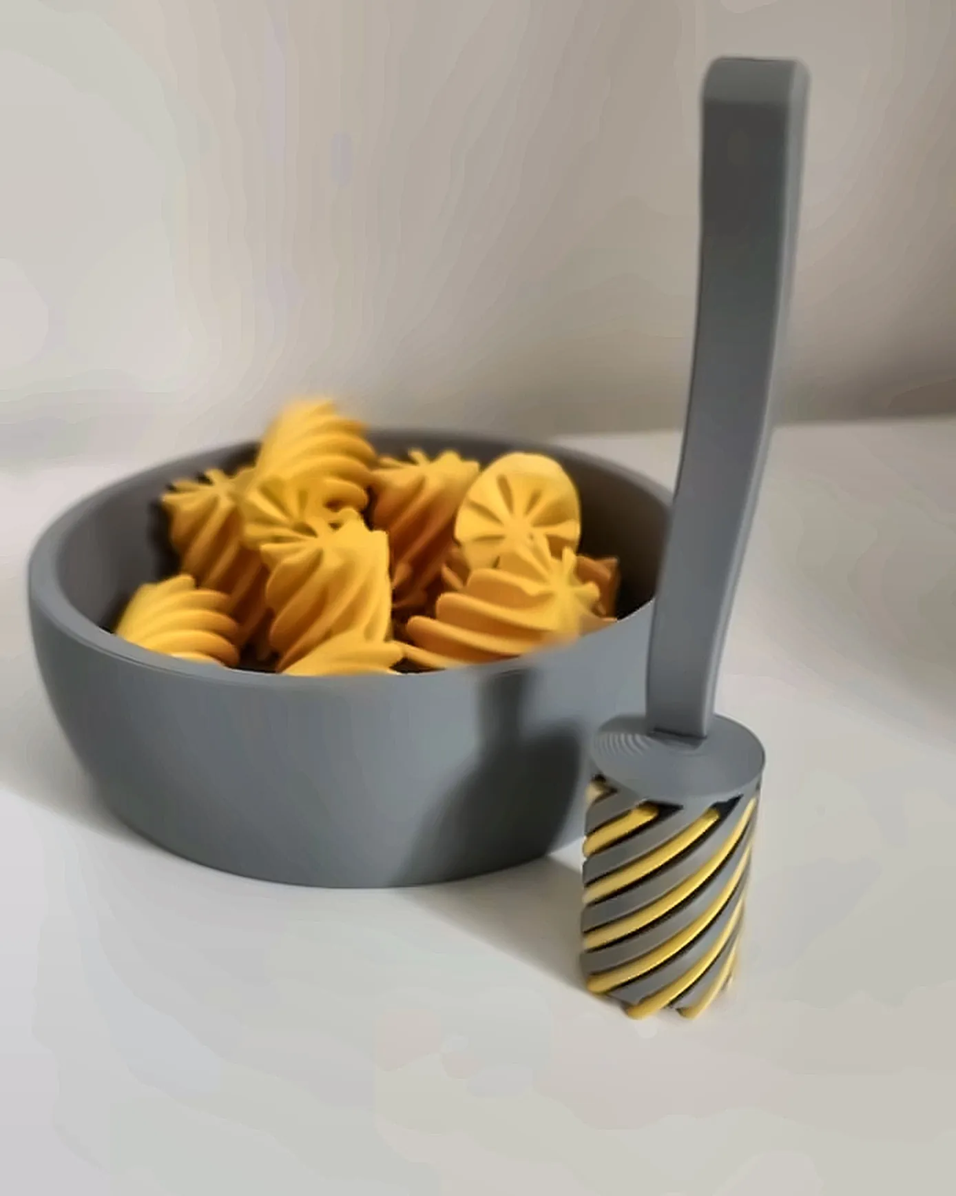 Garfo em espiral em pé ao lado da tigela de massa, impressos em 3D pela Dédalo